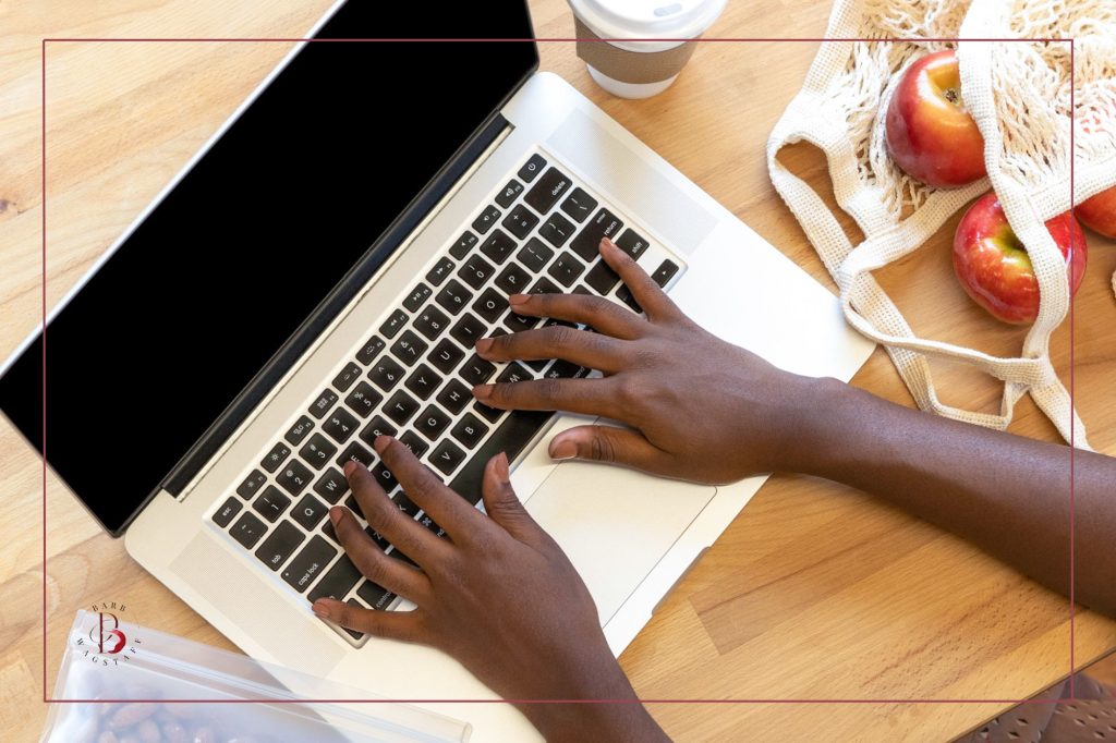 African American woman's hands on keyboard of a laptop