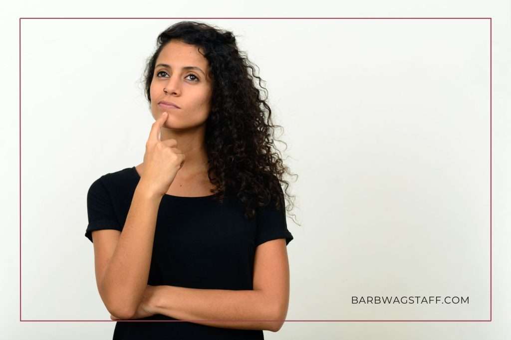 woman with dark hair and black t-shirt looking perplexed
