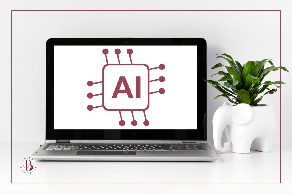 Laptop sitting open on white desk. On the screen is a burgundy AI symbol