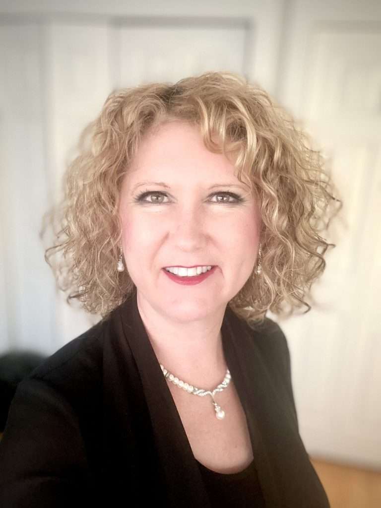 blonde woman with black shirt and pearls