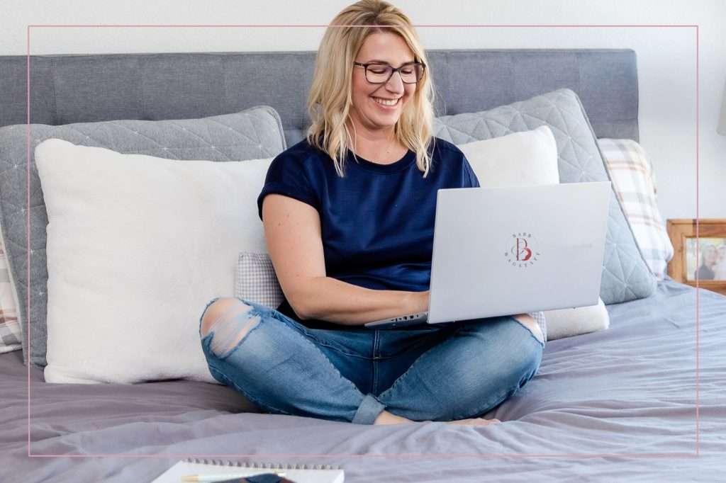 woman sitting on her bed smiling at her computer which provided her the answer to her question with zero click content